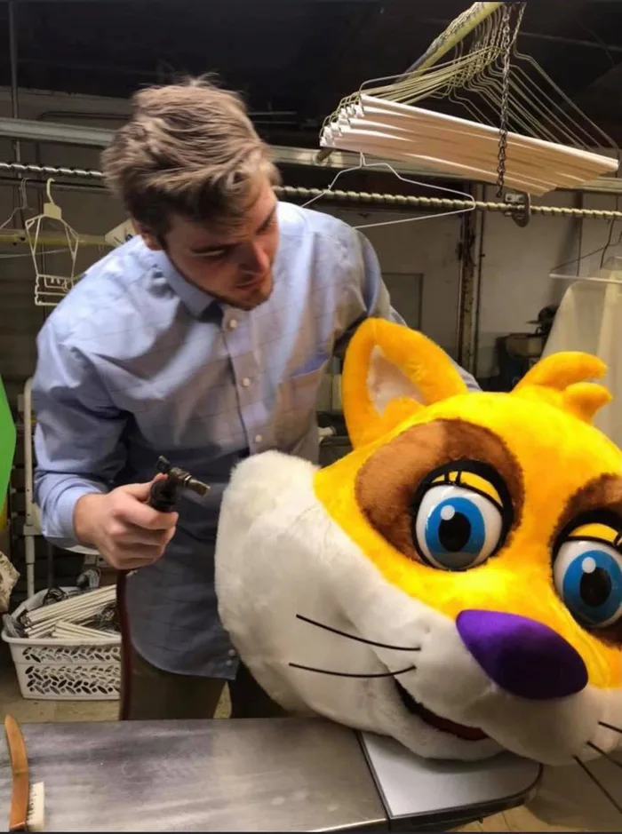 A Faye’s staff member working on a yellow mascot head at the shop