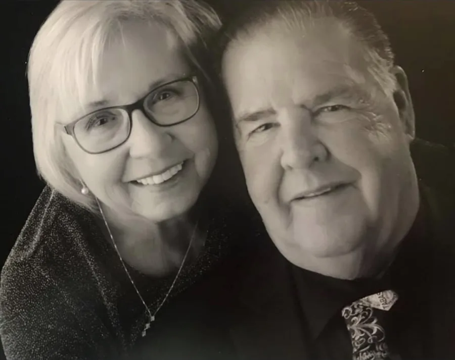 A black-and-white portrait of a smiling couple