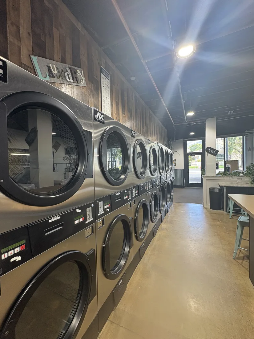 Stacked dryers lining a clean laundromat aisle