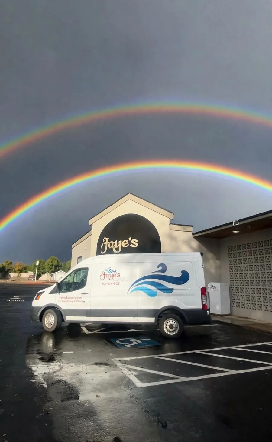 A Faye's delivery van parked outside Faye's under a double rainbow