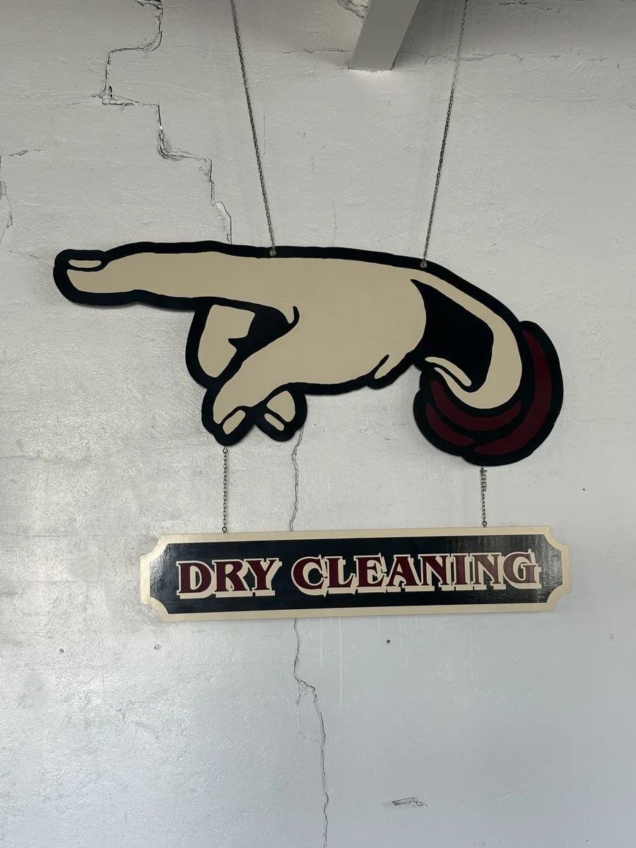 Vintage dry cleaning sign with a pointing hand